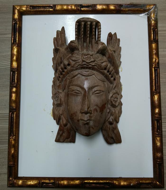 可能是東南亞佛像的雕刻風格，不知是何種木頭的實心木 木刻佛像頭（半面）用一顆螺絲釘鎖在金邊木框上/佛像臉部的表面部份似有